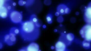 Abstract blue blurred holiday background with magical bokeh of glowing bright light energy small particles of flying dots on a black background video