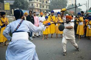 Delhi, India, October 2, 2023 - Sikhs display gatka and martial arts during annual Nagar Kirtan, Traditional, procession on account of birthday of Guru Nanak Dev ji, Nagar Kirtan in East Delhi area photo