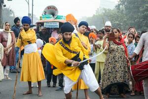 Delhi, India, October 2, 2023 - Sikhs display gatka and martial arts during annual Nagar Kirtan, Traditional, procession on account of birthday of Guru Nanak Dev ji, Nagar Kirtan in East Delhi area photo