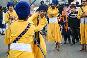 Delhi, India, October 2, 2023 - Sikhs display gatka and martial arts during annual Nagar Kirtan, Traditional, procession on account of birthday of Guru Nanak Dev ji, Nagar Kirtan in East Delhi area photo