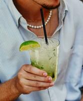 A young person enjoying a rum, lime and mint mojito photo