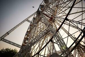 Closeup of multi-coloured Giant Wheel during Dussehra Mela in Delhi, India. Bottom view of Giant Wheel swing. Ferriswheel with colourful cabins during day time. photo