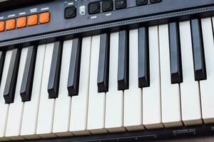 Close-up of piano keys. Piano black and white keys and Piano keyboard musical instrument placed at the home balcony during sunny day. photo