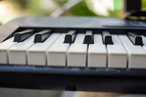 de cerca de piano llaves. piano negro y blanco llaves y piano teclado musical instrumento metido a el hogar balcón durante soleado día. foto