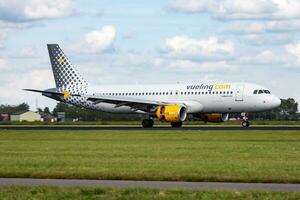 Vueling passenger plane at airport. Schedule flight travel. Aviation and aircraft. Air transport. Global international transportation. Fly and flying. photo