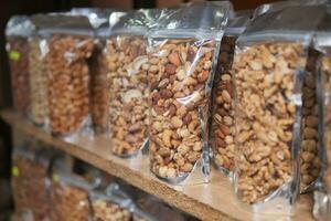many mixed nuts in a plastic packet on shelf photo