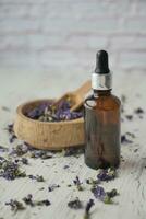 Essential lavender oil and flowers on table with copy space photo