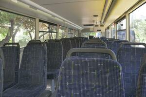 Blue seats inside of empty city bus. photo
