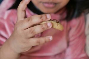 niño comiendo dulce galletas de cerca foto