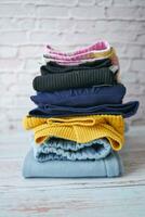 Stack of clothes on table indoor. photo