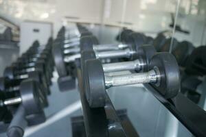 Rows of black color dumbbells with numbers in the gym photo