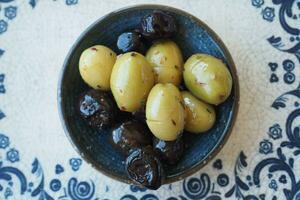 Collection of black and green olives with leaves. photo