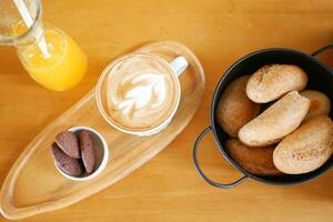 un taza de tarde café con un pan y galletas en mesa foto