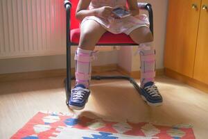 Child cerebral palsy disability, legs orthosis. photo