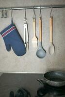 Kitchen utensils hanging on a hanger inside a modern kitchen, photo
