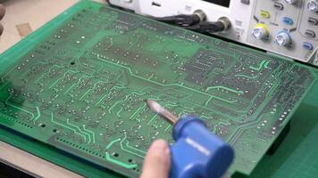 operativo engenheiro reparar de solda a o circuito borda do a eletrônico dispositivo em a mesa.tabuleiro reparar cnc máquina video