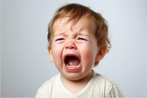 cerca arriba retrato de un linda pequeño chico niño llorando y gritando. aislado en un blanco antecedentes. un blanco caucásico niño con ligero cabello. fuerte emociones de desesperación, dolor, y resentimiento ai generado foto