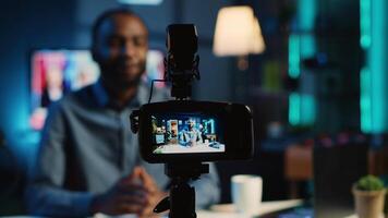 Close up shot on professional recording device in cozy home studio used for filming film video intro for online streaming platforms. Influencer in blurry background greets fanbase, focus on camera