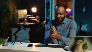 Content creator in dimly lit living room using camera to film keyboard review for online streaming platforms. Online star hosts technology internet show, unboxing peripherals video