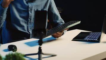 African american technology internet star filming review of newly released wireless keyboard, greeting audience and presenting them feedback about typing experience, doing endorsement video