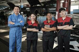 Portrait of multiracial professional mechanic team arms crossed and look at camera, work at car service garage, happy maintenance jobs, check and repair occupation in automotive industry business. photo