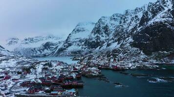 pescaria Vila a, rorbu, mar e montanhas dentro inverno. mosquitos, lofoten ilhas. panorama do Noruega. aéreo visualizar. zangão moscas para trás e para cima video