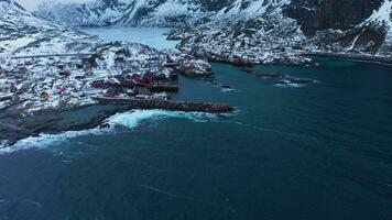 pescaria Vila a, rorbu, mar e montanhas dentro inverno. mosquitos, lofoten ilhas. panorama do Noruega. aéreo visualizar. zangão moscas avançar, inclinar acima. revelar tiro video