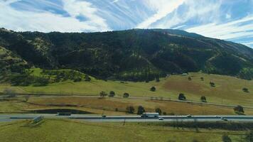 Traffic on Highway 51 and Green Meadow with Hills. Kern County. California, USA. Aerial View. Drone Flies Sideways video