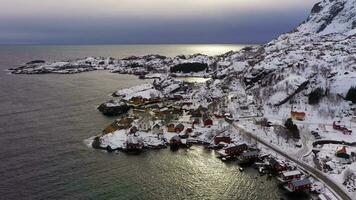 nusfjord pescar aldea, Rorbu, fiordo y montañas en invierno. lofoten islas, Noruega. aéreo vista. zumbido moscas hacia atrás y hacia arriba video