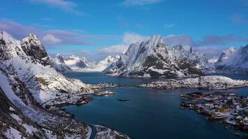 reine Dorf und Berge auf sonnig Winter Tag. olstinden Gipfel. Moskenes, Lofoten Inseln. Landschaft von Norwegen. Antenne Sicht. Drohne fliegt rückwärts und nach oben video