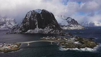 hamnoy pescar pueblo y festhelltinden montaña en invierno. lofoten islas, Noruega. aéreo vista. zumbido moscas oblicuo y hacia arriba video