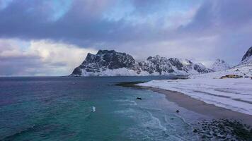 Uttakleiv Beach Norwegian Sea and Mountains in Winter. Lofoten Islands, Norway. Aerial View. Drone Flies Backwards and Upwards video