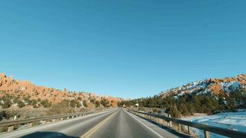 Auto Fahren auf Straße durch rot Schlucht auf Winter sonnig Tag. dixie National Wald. Utah, USA video