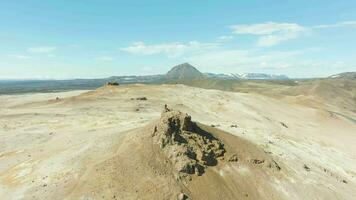 hombre soportes en parte superior de rock en hverir geotermia área. Islandia. aéreo vista. zumbido moscas adelante video