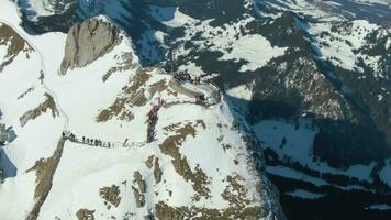 Observation Deck of Mountain Pilatus in Winter Day. Tourists on Viewpoint. Swiss Alps, Switzerland. Aerial View. Drone is Orbiting. Medium Shot video