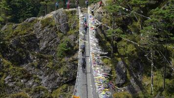 trekkers zijn wandelen Aan suspensie brug in khumbu. Himalaya, Nepal. langzaam beweging video