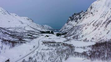 Berge, Straße und gefroren See im Winter. Schlucht. Troms, Norwegen. Antenne Sicht. Drohne fliegt rückwärts und nach oben video