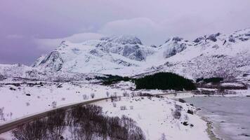 Straße und Berge im Winter. wolkig Himmel. Flakstadoya, Lofoten Inseln, Norwegen. Antenne Sicht. Drohne fliegt nach vorne video