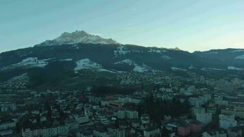 Kriens Stadt und Berg Pilatus beim Sonnenuntergang im Winter. schweizerisch Alpen, Schweiz. Antenne Sicht. Drohne fliegt seitwärts und nach oben video