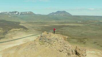 fotograaf Mens nemen afbeeldingen Aan berg top in hverir geothermisch Oppervlakte. IJsland. antenne visie. dar is in een baan om de aarde video