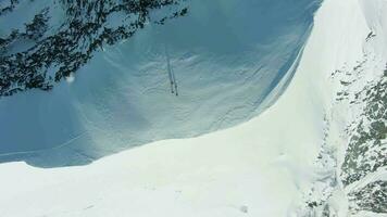 Gruppe von Menschen auf schneebedeckt oben von Berg im europäisch Alpen. Antenne Vertikale von oben nach unten Sicht. Drohne fliegt nach oben und dreht sich video