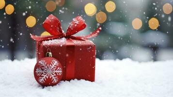 Red Christmas ornament with red wrapping paper and Christmas box on a snowy background photo. photo