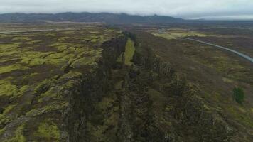 fisuras y grietas en thingvellir nacional parque en verano nublado día. Islandia. aéreo vista. revelar Disparo video