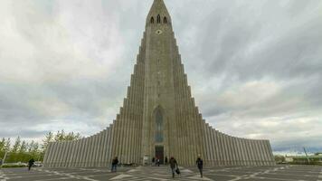 Reykjavik, Iceland - May 21, 2019 Hallgrimskirkja Church and Tourists. Vertical Panning Time Lapse video