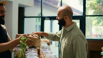 koper genieten van rijk citroen geur van lokaal biologisch supermarkt, kruidenier op te slaan handelaar geven fruit naar cliënt. jong klant ruiken produceren, reclame veganistisch duurzame levensstijl. video