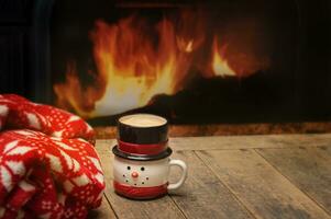 Winter Setting with Blanket and Hot Beverage Next to a Fire photo