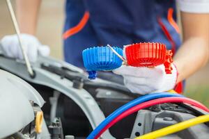 Repairman holding monitor tool to check and fixed car air conditioner system, Technician check car air conditioning system refrigerant recharge, Air Conditioning Repair photo