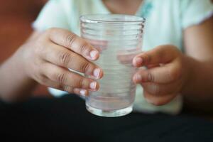 child hand holding a empty glass , photo