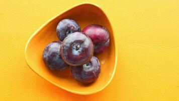 Fresh plums in a bowl on table video