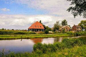 a house and a river in the countryside photo